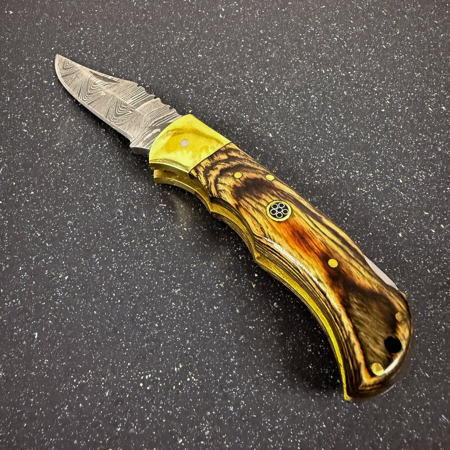 Navaja deportiva de acero damasco artesanal fabricada a mano.