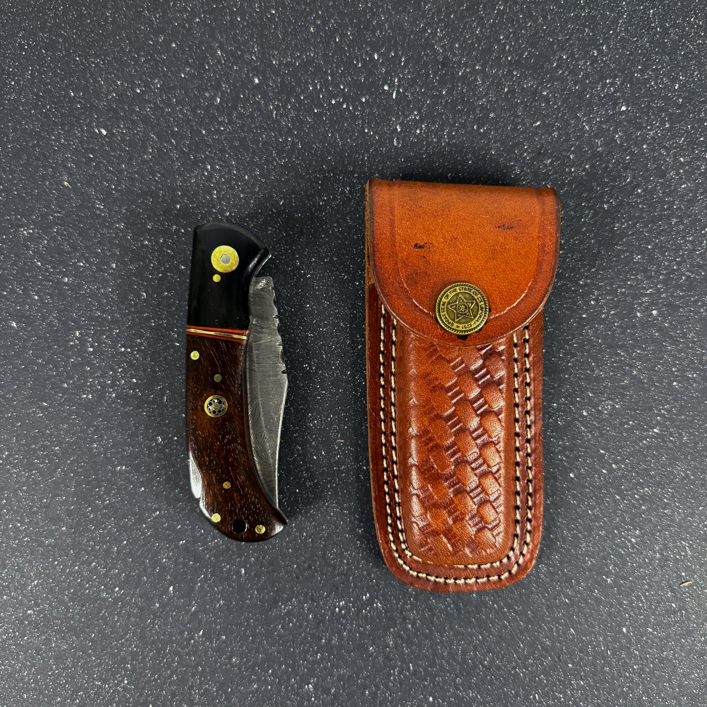 Navaja deportiva de acero damasco artesanal fabricada a mano. 