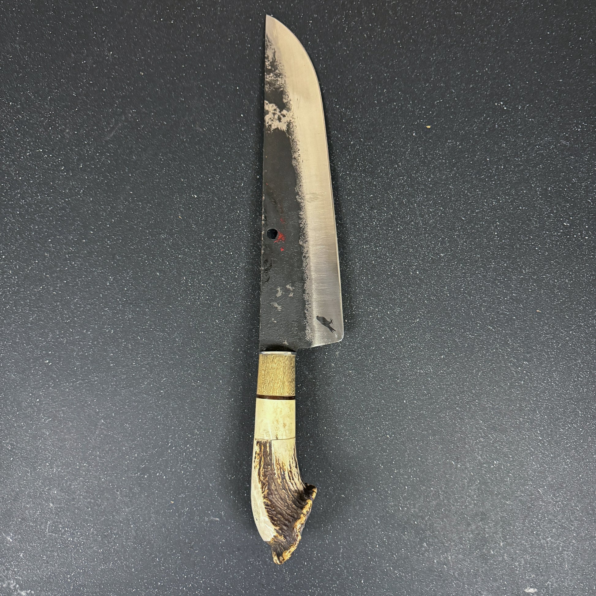 Cuchillo parrillero artesanal Ciprés Rauka sobre fondo oscuro elegante.